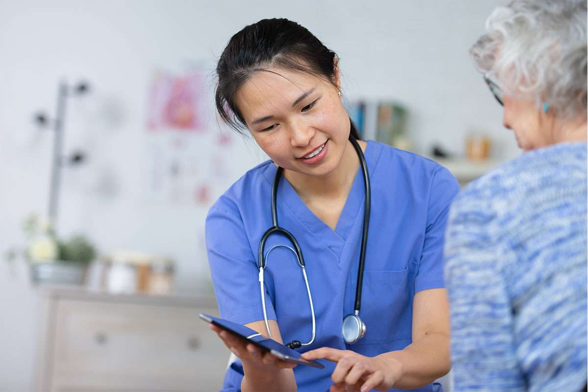 Clinician with a patient looking at data on a tablet.