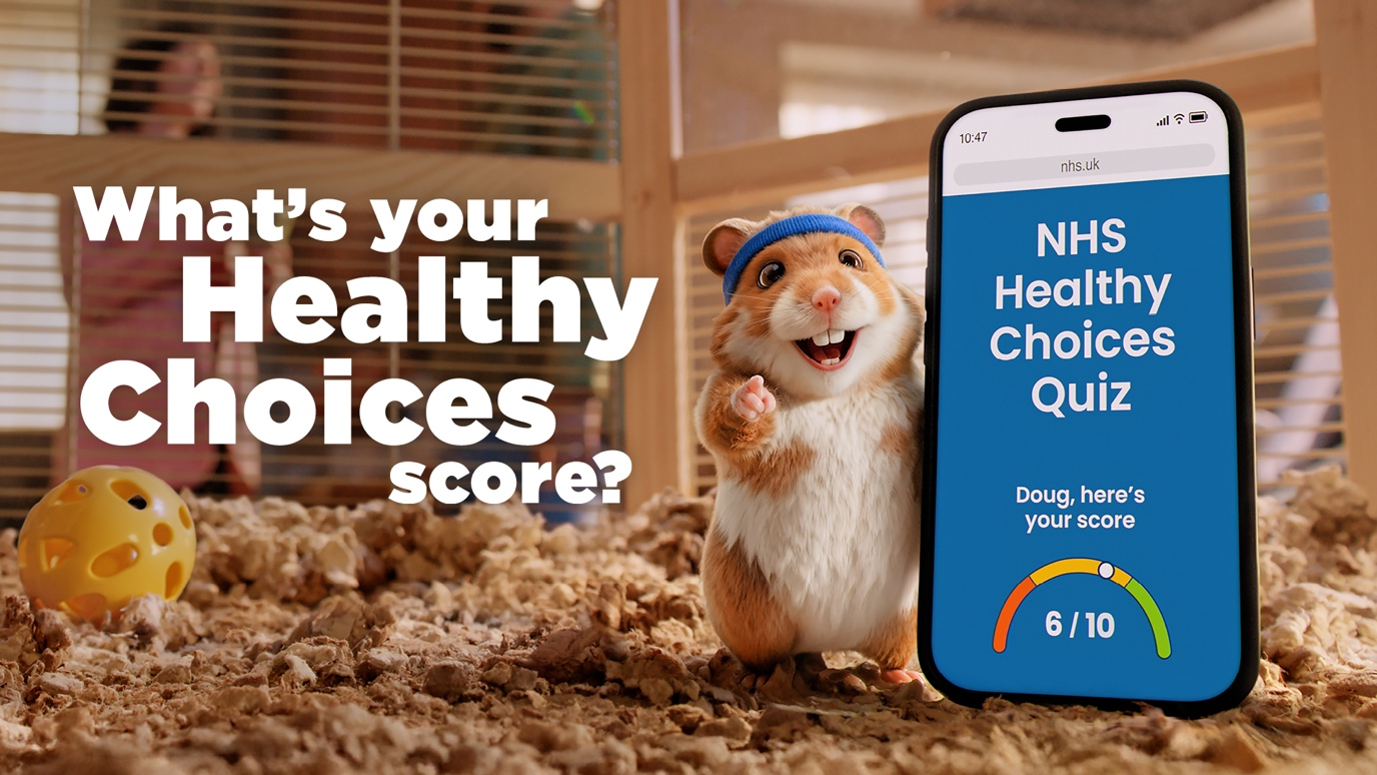 Kenny the hamster mascot, holding a mobile phone showing the NHS Healthy Choices Quiz page. Wording on the mobile phone page says 'Doug, here's your score - 6 out of 10. The text on the image says 'What's your Healthy Choices score?'