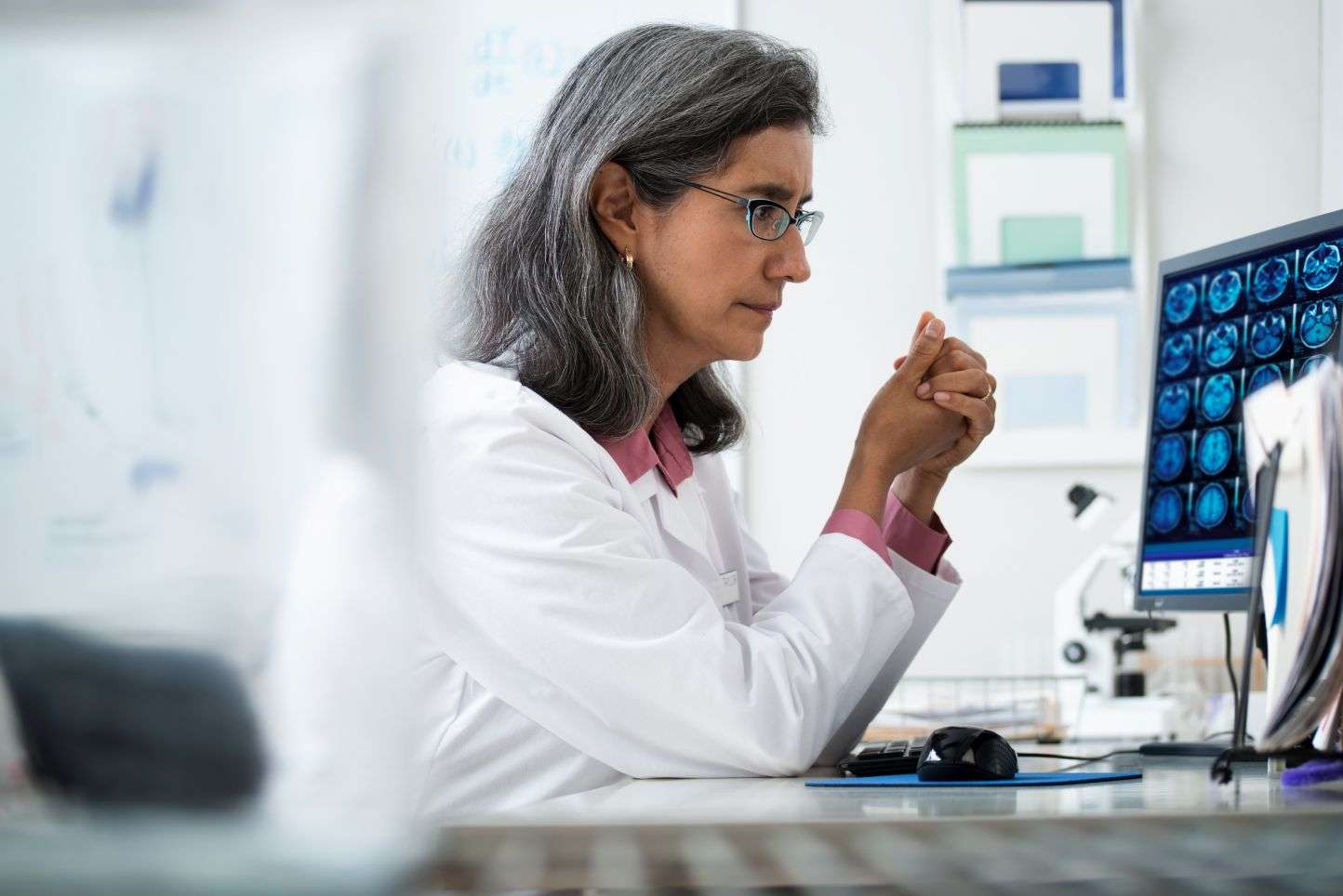 Clinician looking at computer screen showing medical data.